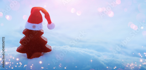 Christmas background with red fir tree on white snow.