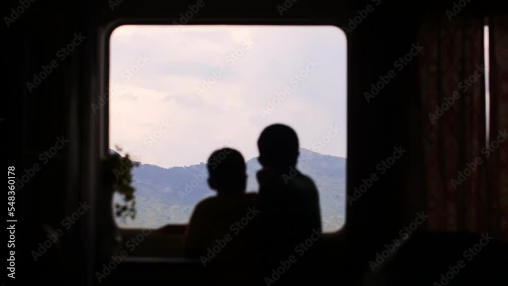 Children look out the window on the ferry and discuss the view from the window Children look out the window on the ferry and discuss the view from the window