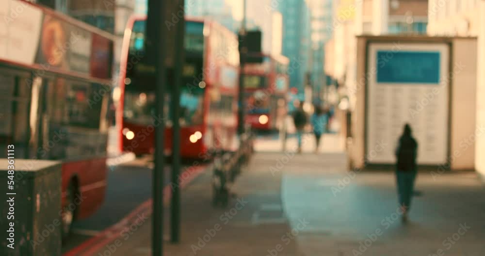 City morning, line of red buses in street busy with traffic on a summer day in London. Travel, tourism in England and public transport with double decker bus driving on schedule, commute in cityscape