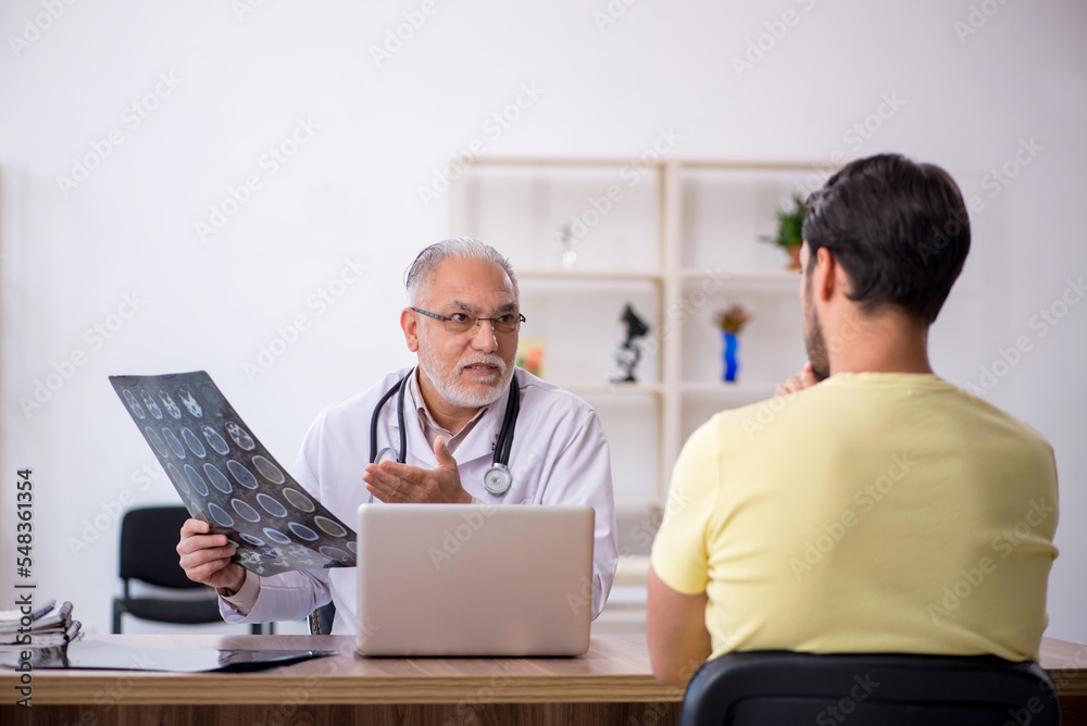 Young male doctor visiting old male doctor radiologist Young male doctor visiting old male doctor radiologist