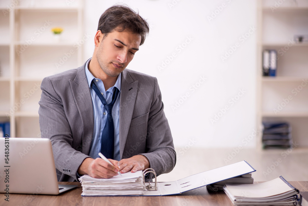 Young male employee working in the office Young male employee working in the office