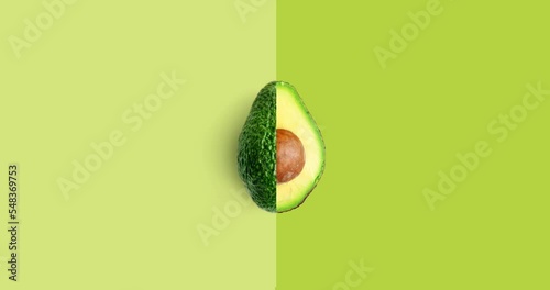 Creative animation made of avocado full an peeled on the green background. Animation concept food.  photo