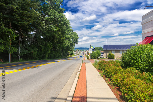 straight road through a small town stretching towards the horizon. The road along the hotels markets and gas stations. Blue sky and magnificent clouds.