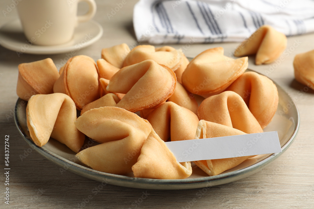 Tasty fortune cookies and paper with prediction on wooden table, closeup. Space for text Tasty fortune cookies and paper with prediction on wooden table, closeup. Space for text