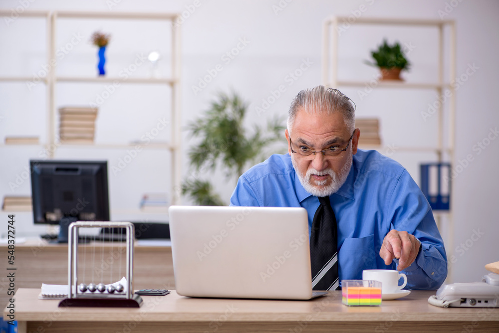 Old male employee working in the office Old male employee working in the office