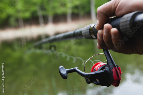 Hands of a man in a Urp plan hold a fishing rod Fototapet