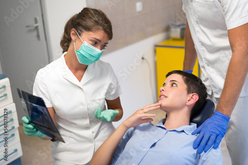 Young woman checking her teeth at the dentist clinic	