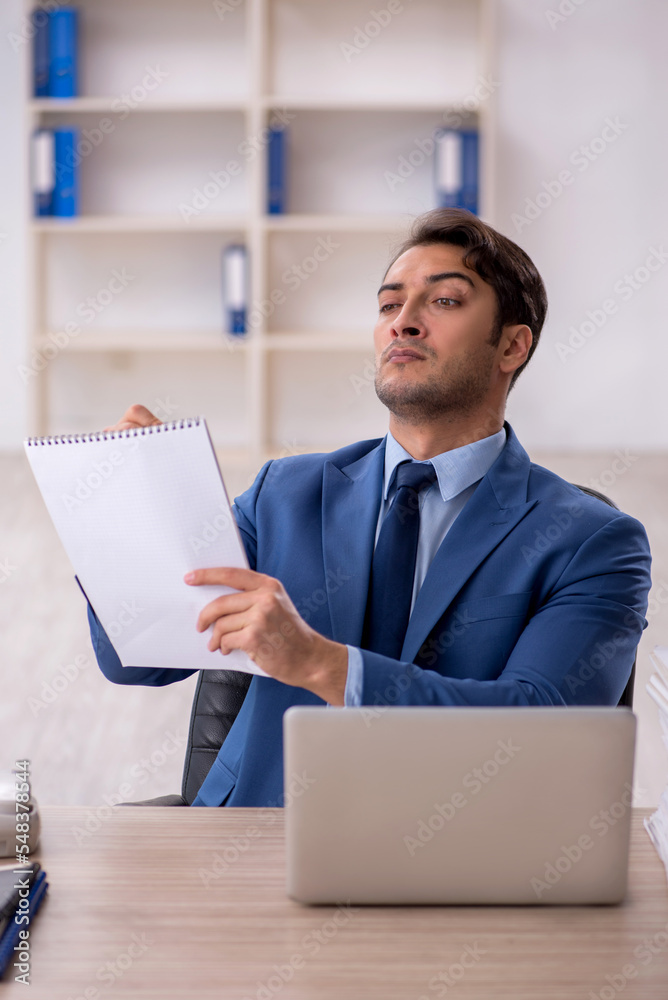 Young male employee and too much work in the office Young male employee and too much work in the office