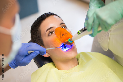 Young woman checking her teeth at the dentist clinic 