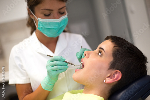 Young woman checking her teeth at the dentist clinic 