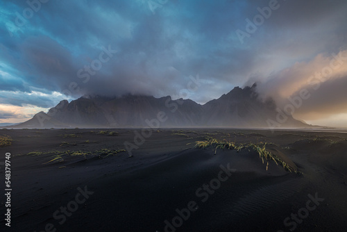Vestrahorn mountains over sunrise with clouds.