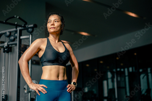 Asian woman fit stand with confidence after abs abdomen cardio workout exercise in fitness. sportswoman fitness in sportswear show six pack and abs muscle at gym club.Fitness, healthy style concept.