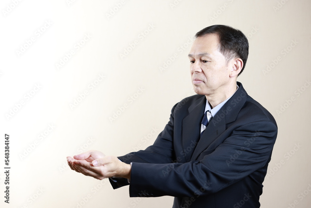 Middle-aged Japanese male businessman wearing navy blue suit on white background. Conceptual image of a project proposal, strategic business success and negotiation closing. Middle-aged Japanese male businessman wearing navy blue suit on white background. Conceptual image of a project proposal, strategic business success and negotiation closing.