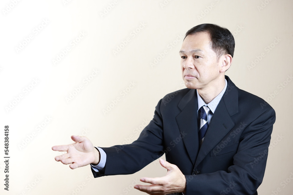 Middle-aged Japanese male businessman wearing navy blue suit on white background. Conceptual image of a project proposal, strategic business success and negotiation closing. Middle-aged Japanese male businessman wearing navy blue suit on white background. Conceptual image of a project proposal, strategic business success and negotiation closing.