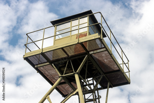 Metal construction of the watchtower, blue sky with clouds in the background