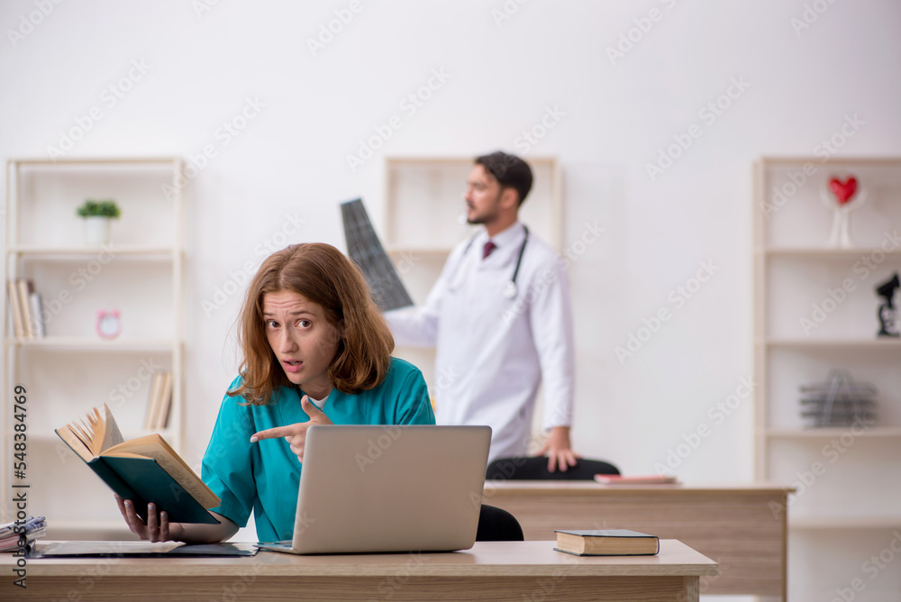 Young male doctor and female assistant working in the clinic Young male doctor and female assistant working in the clinic