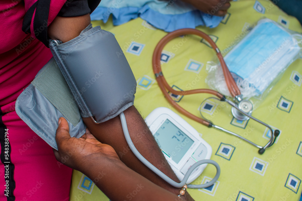 A care giver checking blood pressure of a medical patient with an advance technological device