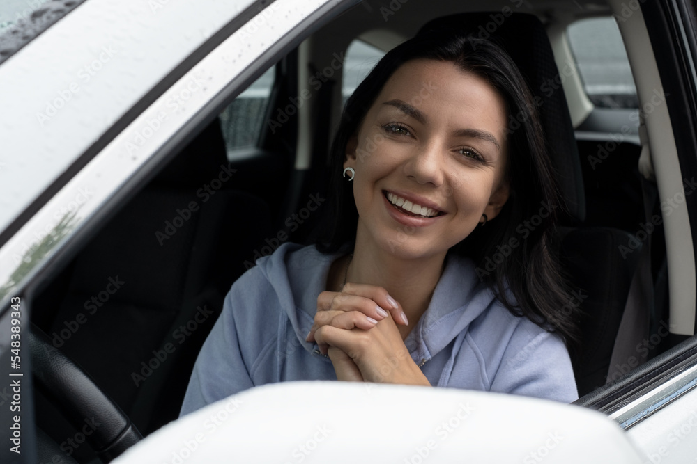 A happy, enjoying young woman driver sits in her car. Road trip concept A happy, enjoying young woman driver sits in her car. Road trip concept