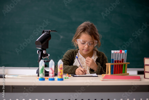 Young little girl chemist in drugs synthesis concept photo