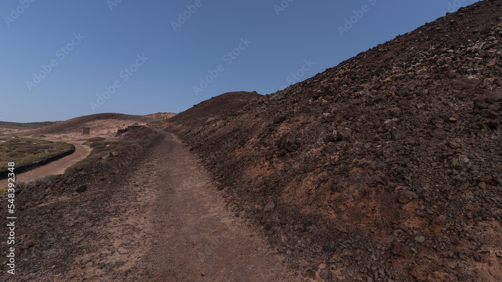 Black desert with many volcanic rocks and small road, Lobos Island Black desert with many volcanic rocks and small road, Lobos Island