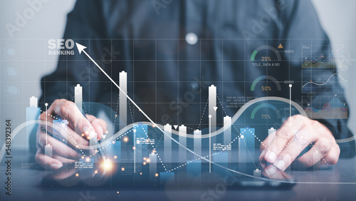 фотографія A marketer holds a pen pointing to a graph and shows SEO concepts, optimization analysis tools, search engine rankings, social media sites based on results analysis data