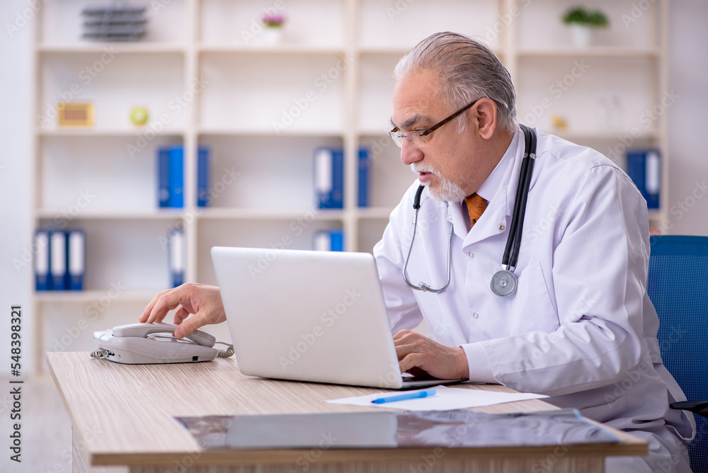 Old male doctor in telemedicine concept Old male doctor in telemedicine concept