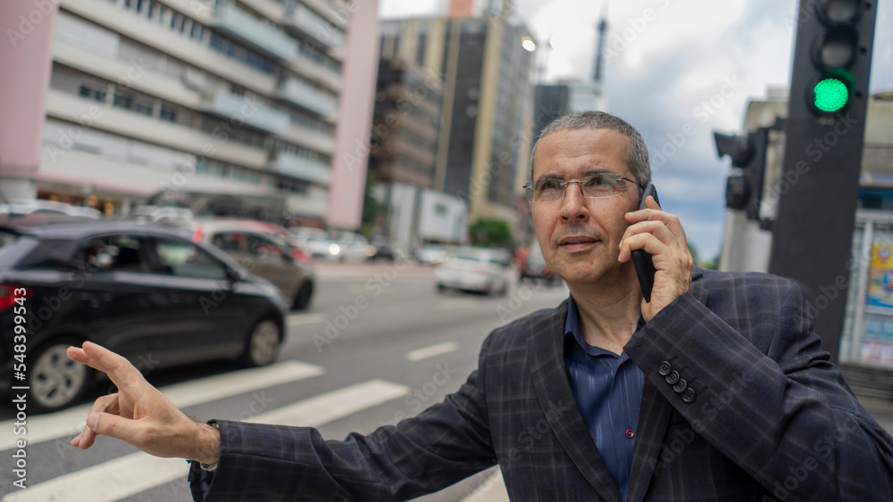Businessman smiling while talking on the phone on the way to work Businessman smiling while talking on the phone on the way to work