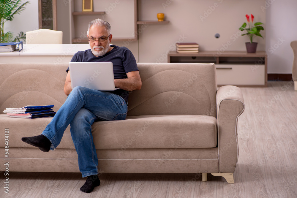 Old male employee working from home during pandemic