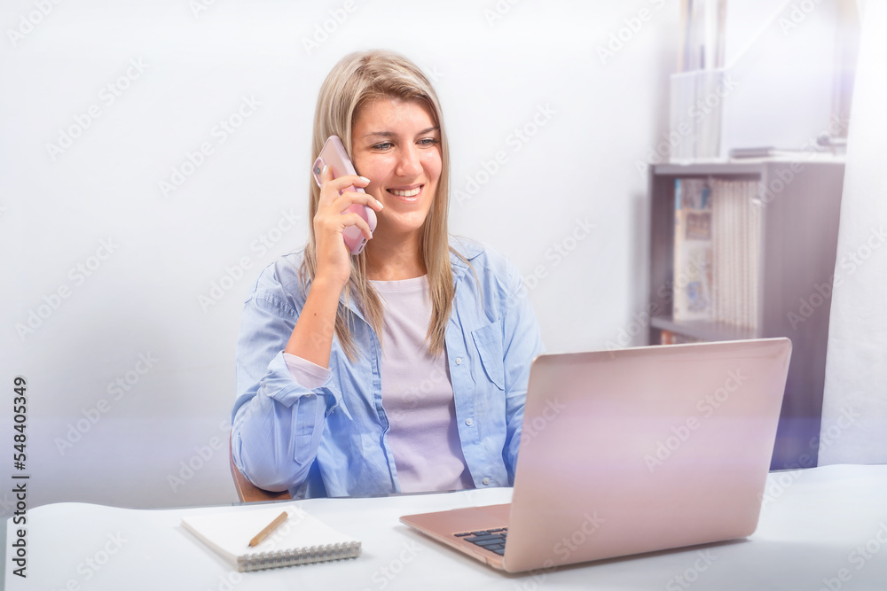 Girl talking on the phone and working online Girl talking on the phone and working online