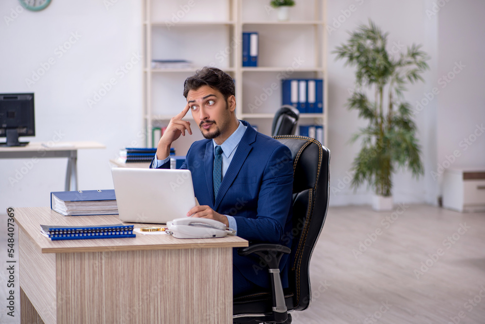 Young male employee working in the office Young male employee working in the office