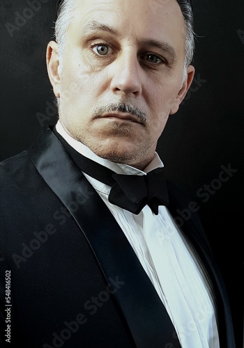 Vertical portrait of an adult Caucasian man in a tuxedo, an Italian mafia boss
