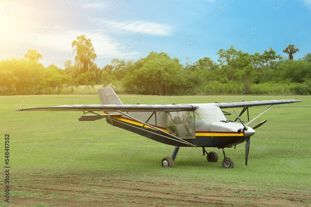 View of beautiful ultralight airplane in field on autumn day View of beautiful ultralight airplane in field on autumn day