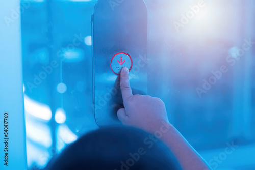 Hand pressing elevator button.