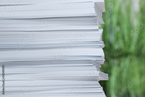 Stack of paper sheets against blurred background, closeup. Space for text