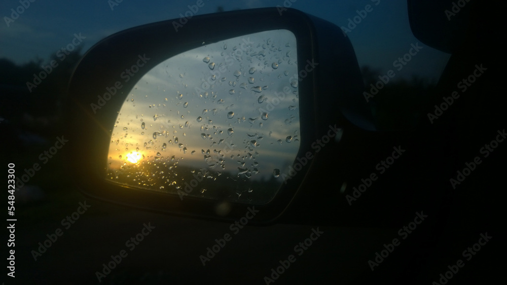 view in the side mirror of the rear view of the car