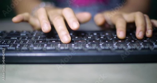 Closeup of asian Indonesian student hands working at communication project typing information on keyboard using computer sitting at desk in living room. Woman searching business email photo