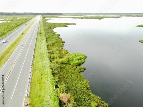 Landscape of a two-lane road over the water surrounded by greenery photo