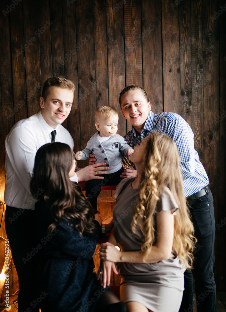 Happy smiling family at studio on background of the Christmas tree with gift Happy smiling family at studio on background of the Christmas tree with gift