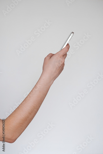 right hand of a freelancer on the side holding a white phone on a white background