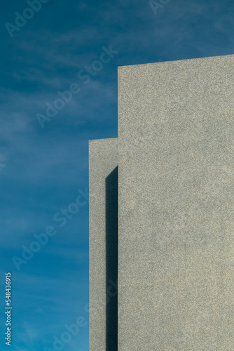 The corner of the modern building on the blue sky backdrop.