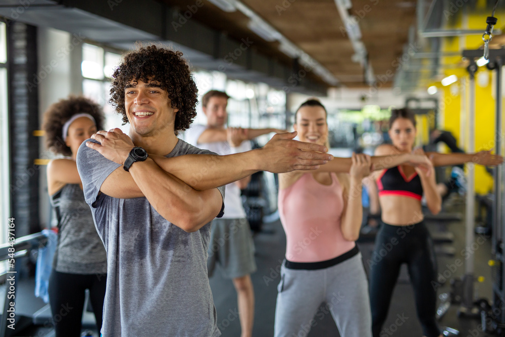Group of young people, friends smiling and enjoy sport in gym. People exercise, work out concept. Group of young people, friends smiling and enjoy sport in gym. People exercise, work out concept.