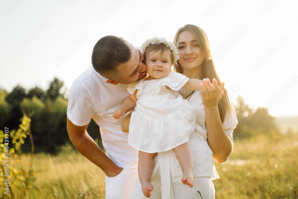 Young family with cute little daughter walking in forest on the sunset Young family with cute little daughter walking in forest on the sunset