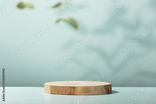 Fototapeta Naklejka Na Ścianę i Meble -  Wood slice podium with eucalyptus leaves on blue background for cosmetic product mockup