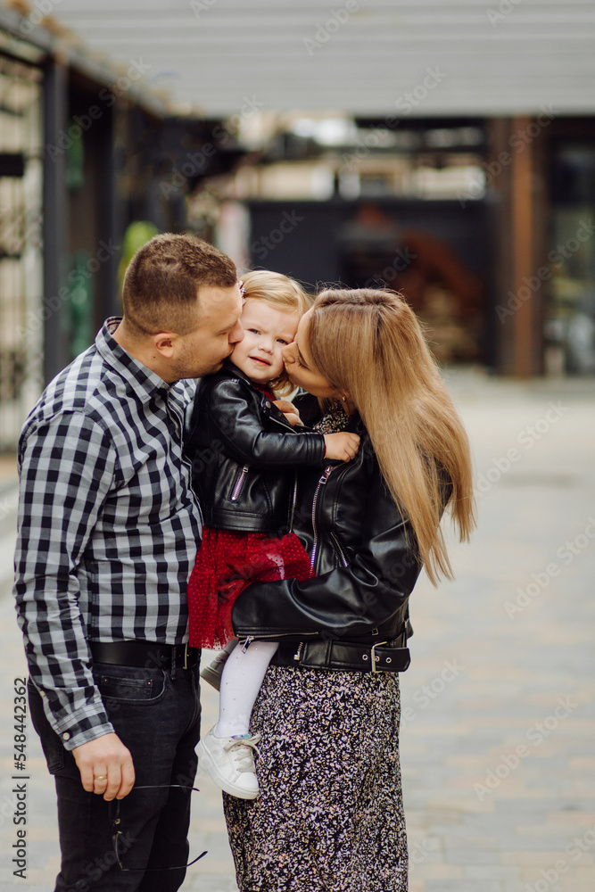Parents and daughhter walking around the city. Spend time together. They are happy Parents and daughhter walking around the city. Spend time together. They are happy