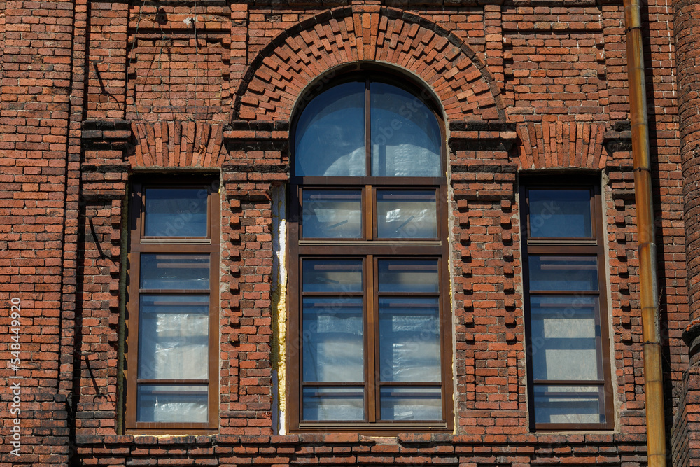 A crumbling historic building in Russia. Historic building in poor condition. Windows of an old house.