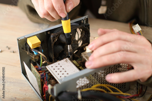 person checking computer power supply on table