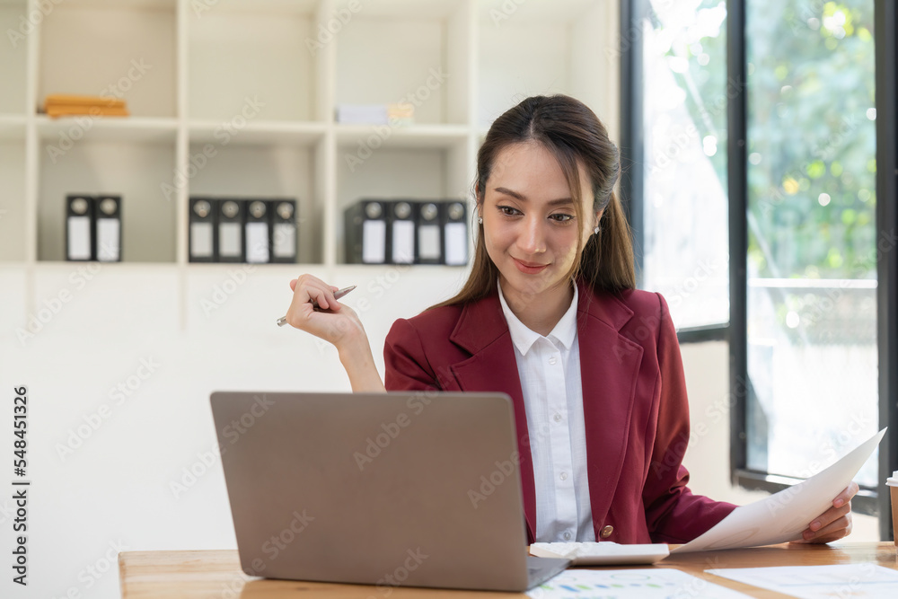 Portrait of young asian business woman using laptop computer for financial paperwork analysis. Portrait of young asian business woman using laptop computer for financial paperwork analysis.