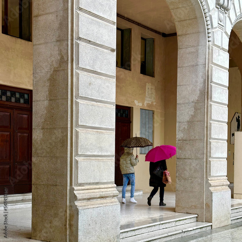 coppia con ombrelli sotto il portico © albasu