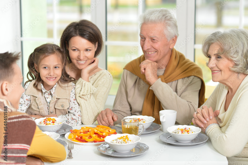 Happy family of different generations eating together 