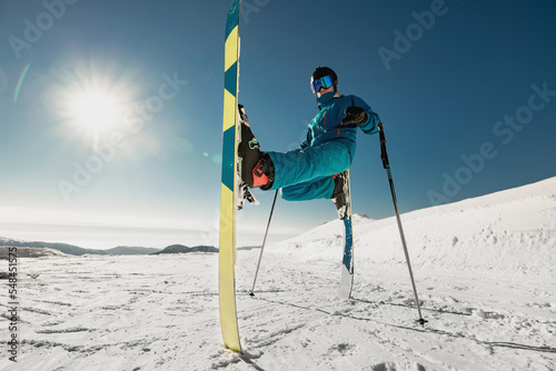Agile young skier doing a trick while standing still. Ski resort